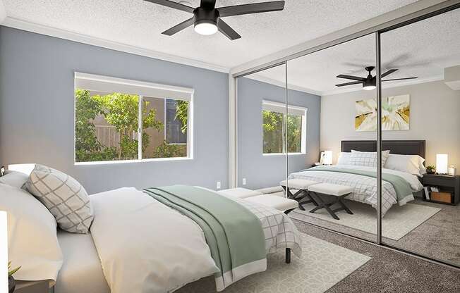 Carpeted bedroom with ceiling fan and large mirrored closets.