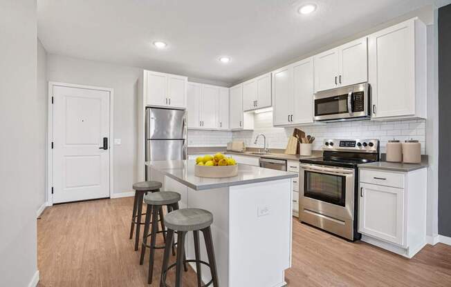 A kitchen with white cabinets and a wooden floor.