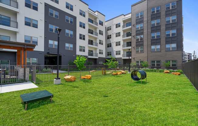 A playground area with a green bench and a green ball in the middle of the grass.