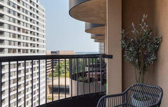 a balcony with two chairs and a table and a building in the background