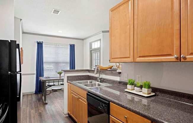 A kitchen with wooden cabinets and a black refrigerator.