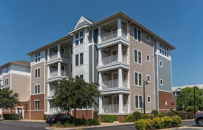 an apartment building with balconies and cars parked in front