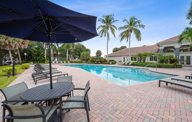 a swimming pool with tables and chairs and umbrellas