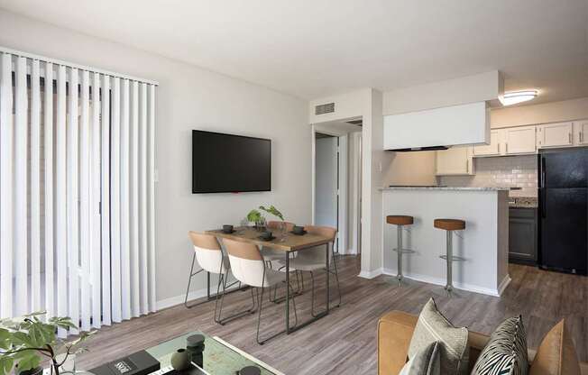 A modern living room with a dining table and chairs.