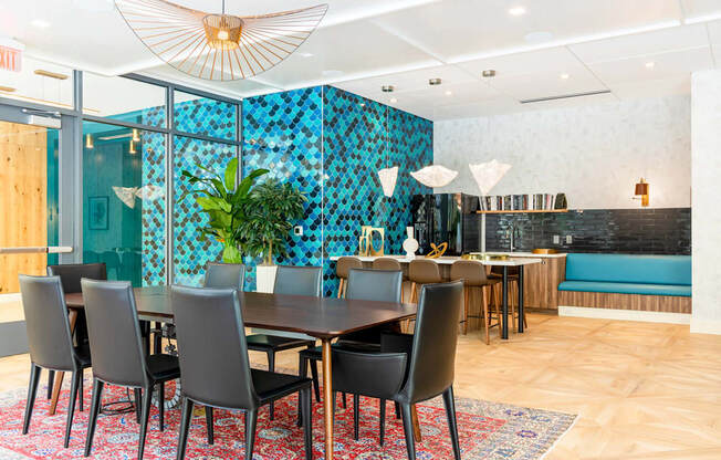 A dining room with a table set for six with chairs around it.