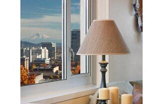 a lamp and candles on a table next to a window