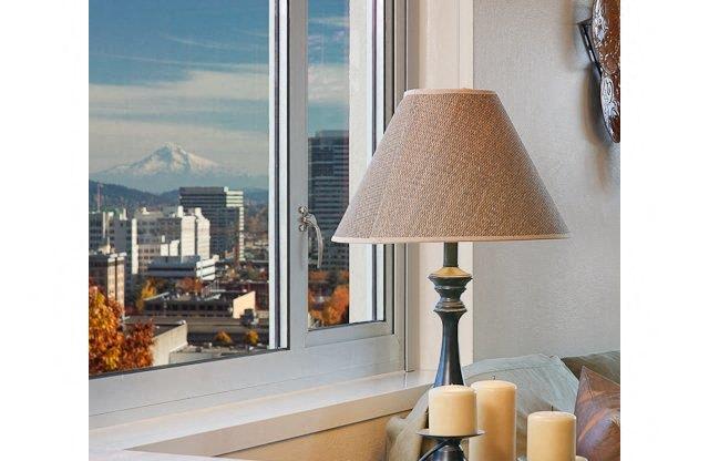 a lamp and candles on a table next to a window