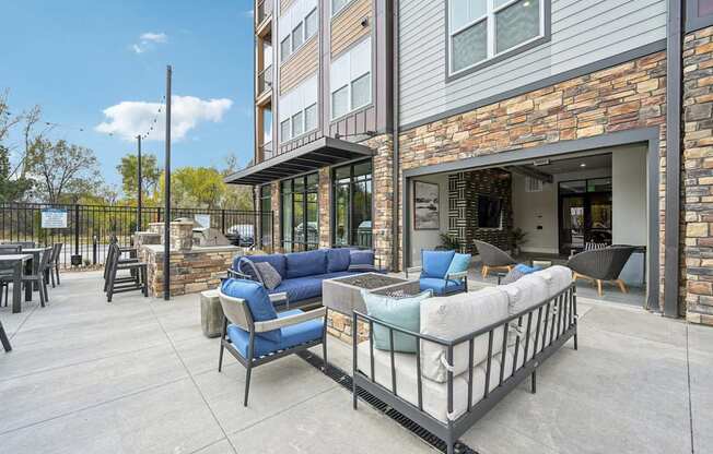 Outdoor community space with chairs barn doors and BBQ grills at The Quarry Luxury Apartment Homes, Fort Collins, Colorado