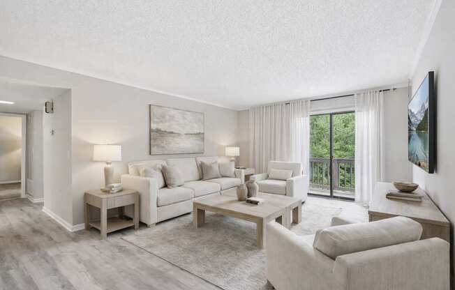 A well-lit, spacious living room with a large window and a view of the outdoors.