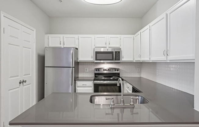 A kitchen with white cabinets and stainless steel appliances.