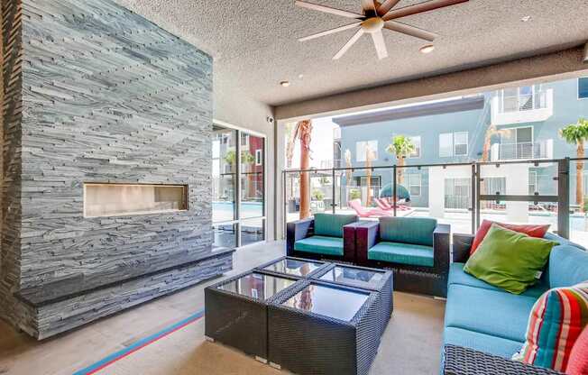 A modern living room with a stone fireplace and a glass coffee table.