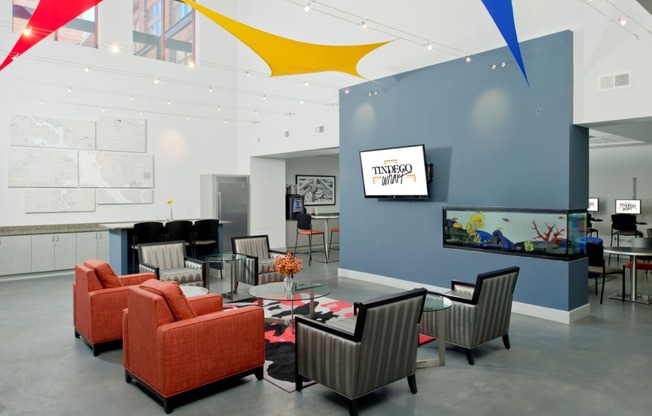 a conference room with orange chairs and a glass table and a wall with graphic design at Tindeco Wharf, Baltimore