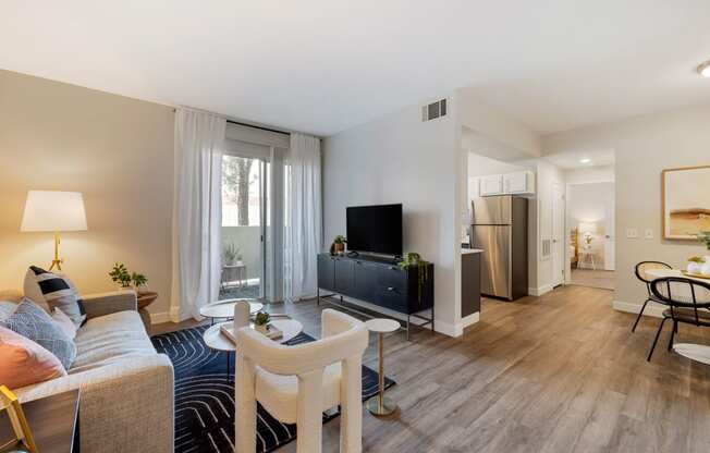 a living room with a couch and a tv at Paisley and Pointe Apartments, Las Vegas