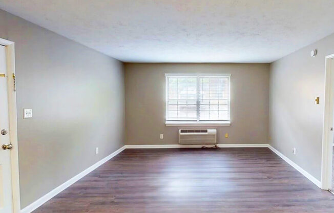 A room with a window and a heater.