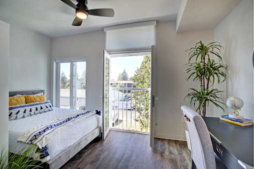 A bedroom with a bed, desk, and chair.