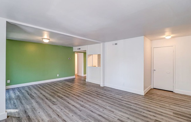 a living room with green and white walls and a wooden floor