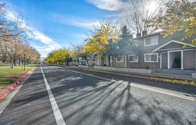 A street with houses on both sides and trees with yellow leaves.