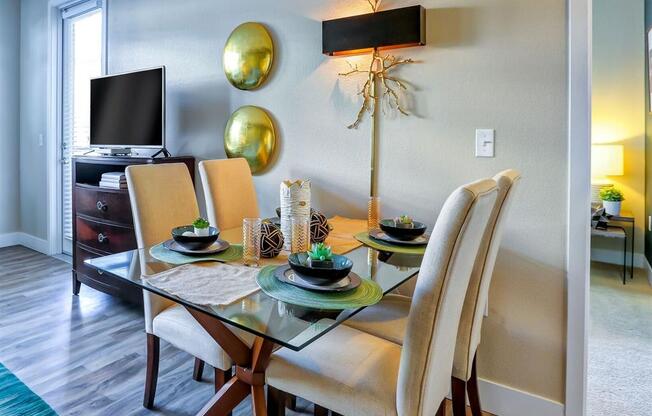 a dining room with a table and chairs and a television in the background