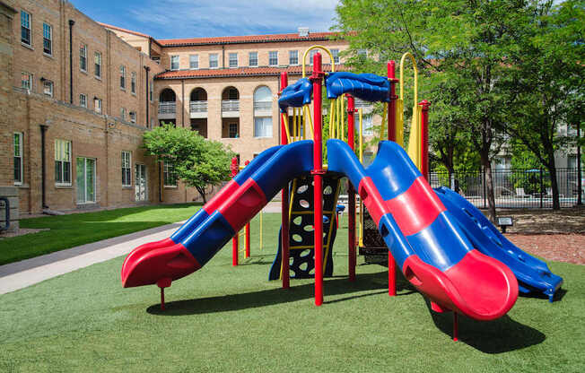 A red and blue slide in a playground.