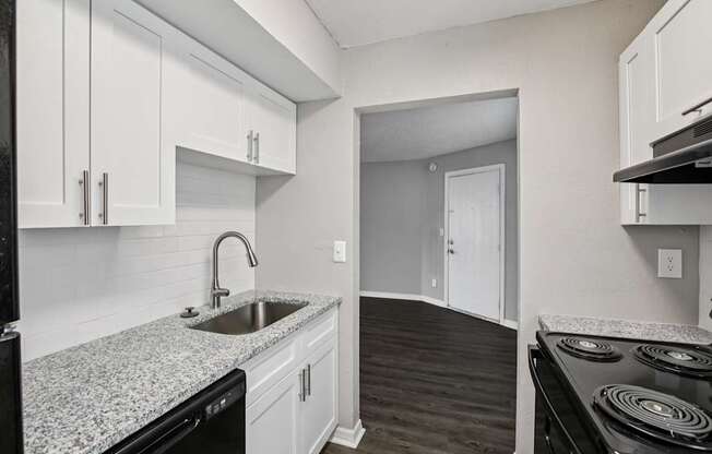 A kitchen with white cabinets and a black stove top oven.
