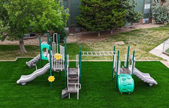 A playground with a green slide and a yellow flower.