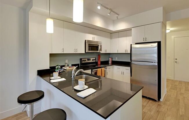 a kitchen with an island and a stainless steel refrigerator