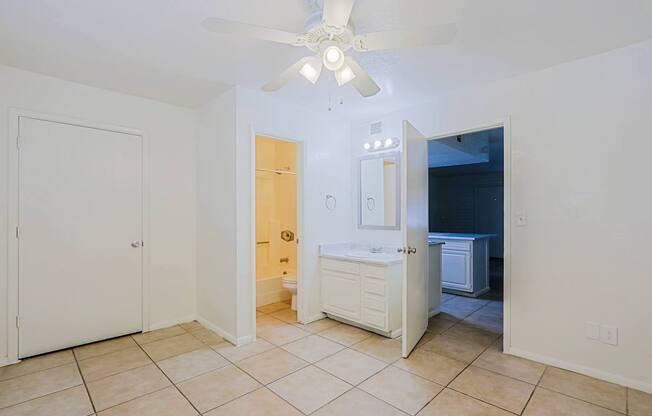 A room with a ceiling fan and tiled flooring.
