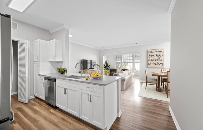 Open kitchen with peninsula seating, white cabinetry, and connected living and dining spaces that support effortless flow throughout the home.