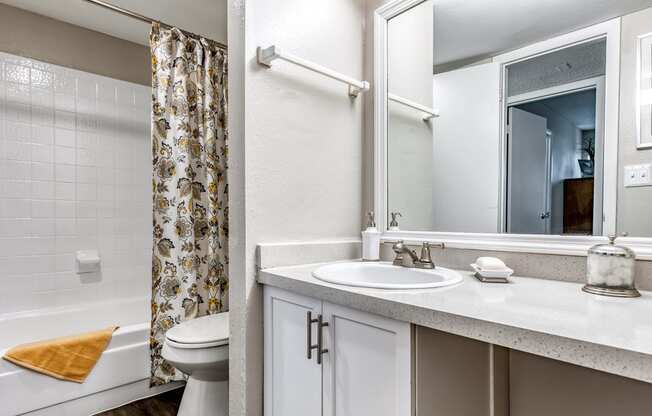 a bathroom with a shower and a sink and a toilet