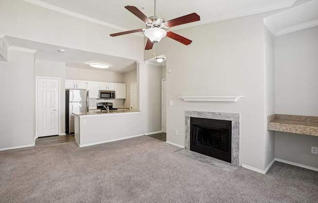 A living room with a fireplace and a ceiling fan.
