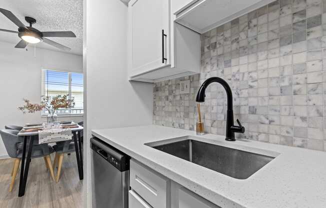 the kitchen and dining area of a house with a sink
