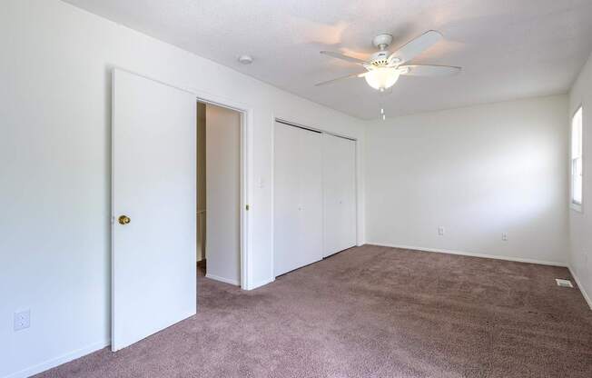A room with a ceiling fan and carpeted floor at Spring Creek Townhomes Apartments, Illinois