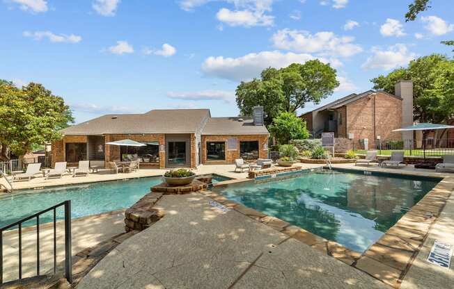 A pool surrounded by a patio and a house.
