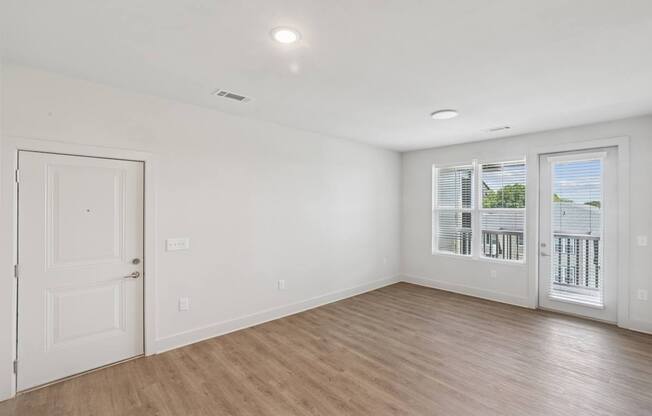 A room with a door and a window with blinds.