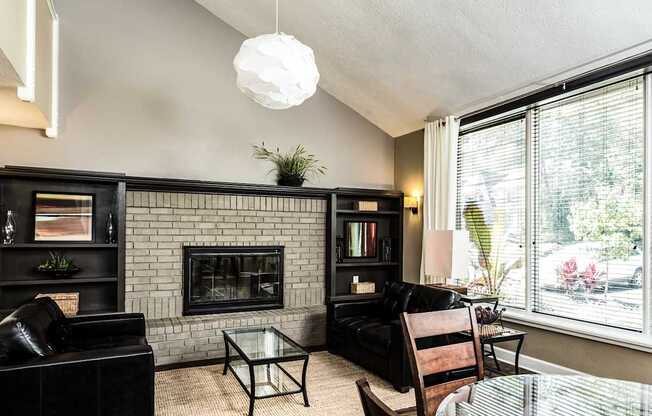 A living room with a fireplace and a glass table.