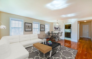 living area with large windows, sofa, coffee table, hardwood floors and view of dining area at hillside terrace apartments in washington dc