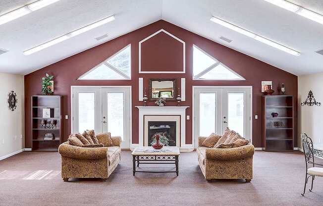 A living room with a fireplace and two chairs.
