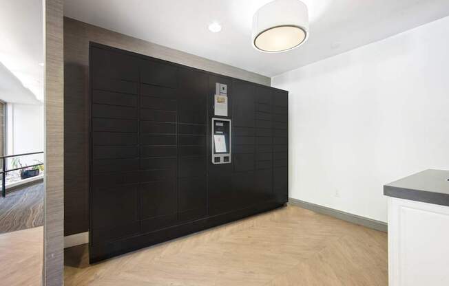 A modern kitchen with a black tile backsplash and wooden flooring.