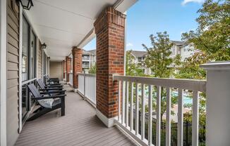 Covered veranda with rocking chair seating and neighborhood views, offering a comfortable place to enjoy fresh air and connect with the community.
