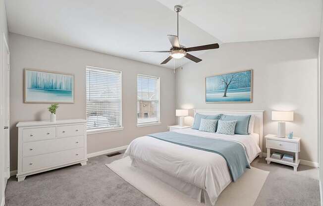 A bedroom with a bed, dresser, and ceiling fan.