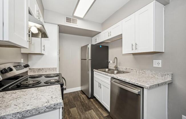 Model kitchen with white cabinets and a granite countertop.