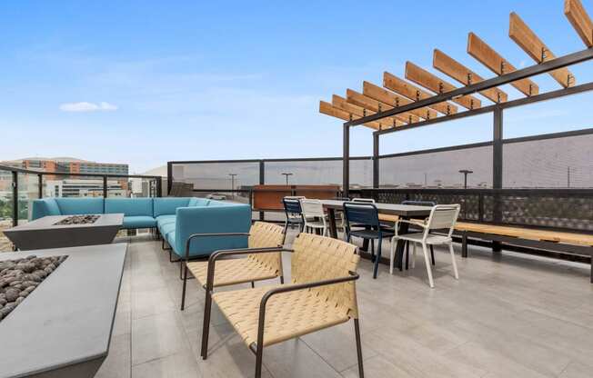 a rooftop patio with tables and chairs and a blue couch