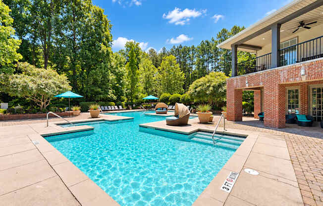 Swimming pool with shaded daybeds and a covered clubhouse patio at Elevation 3505 Apartments & Townhomes in Atlanta, GA.