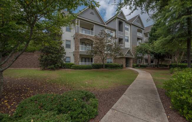 an apartment building with a sidewalk in front of it