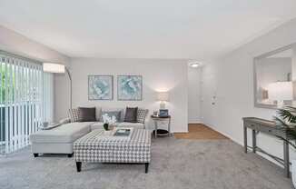 a living room with grey carpet and white walls