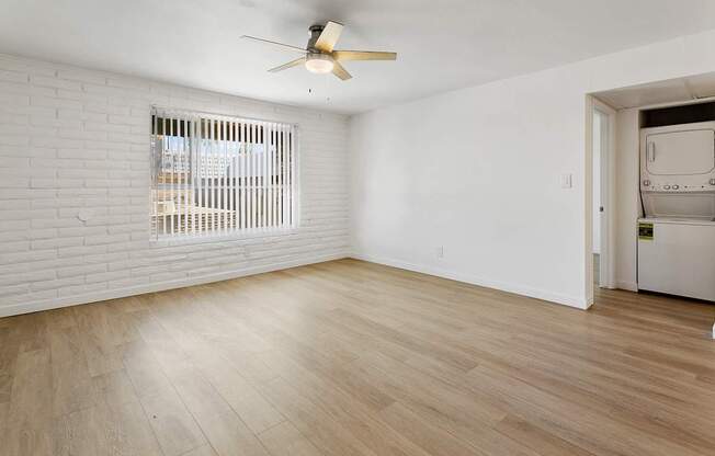 A room with a ceiling fan and wooden flooring.