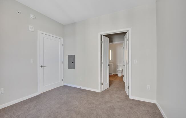 a bedroom with grey carpet and white walls