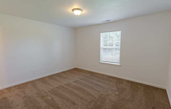 an empty room with carpet and a window