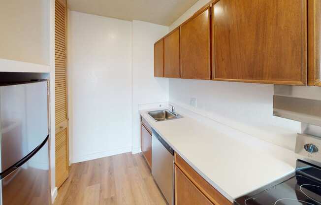 a kitchen with white countertops and wooden cabinets