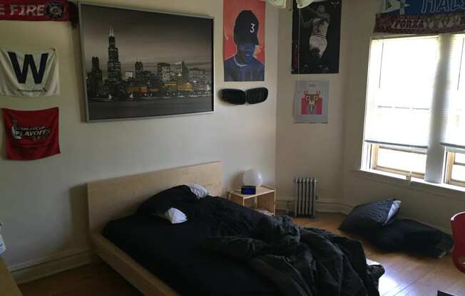 a bedroom with a bed and posters on the wall